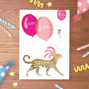 Birthday card with a leopard with a feather headdress hold balloons saying 'Happy Birthday', while a mouse holding a balloon saying 'to you' floats away,