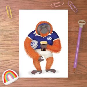 Greetings card with an orangutan wearing a Scottish rugby kit, holding a rugby ball and a pint of stout.