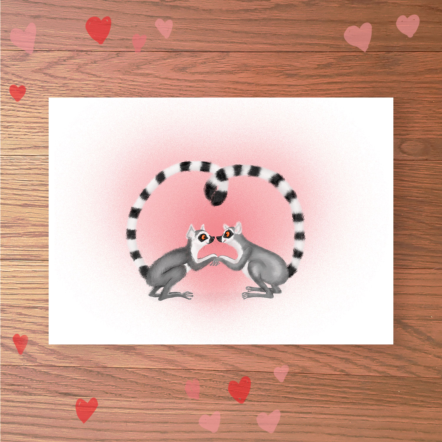 Greetings card with two lemurs holding hands, with their tails entwined in a heart shape.