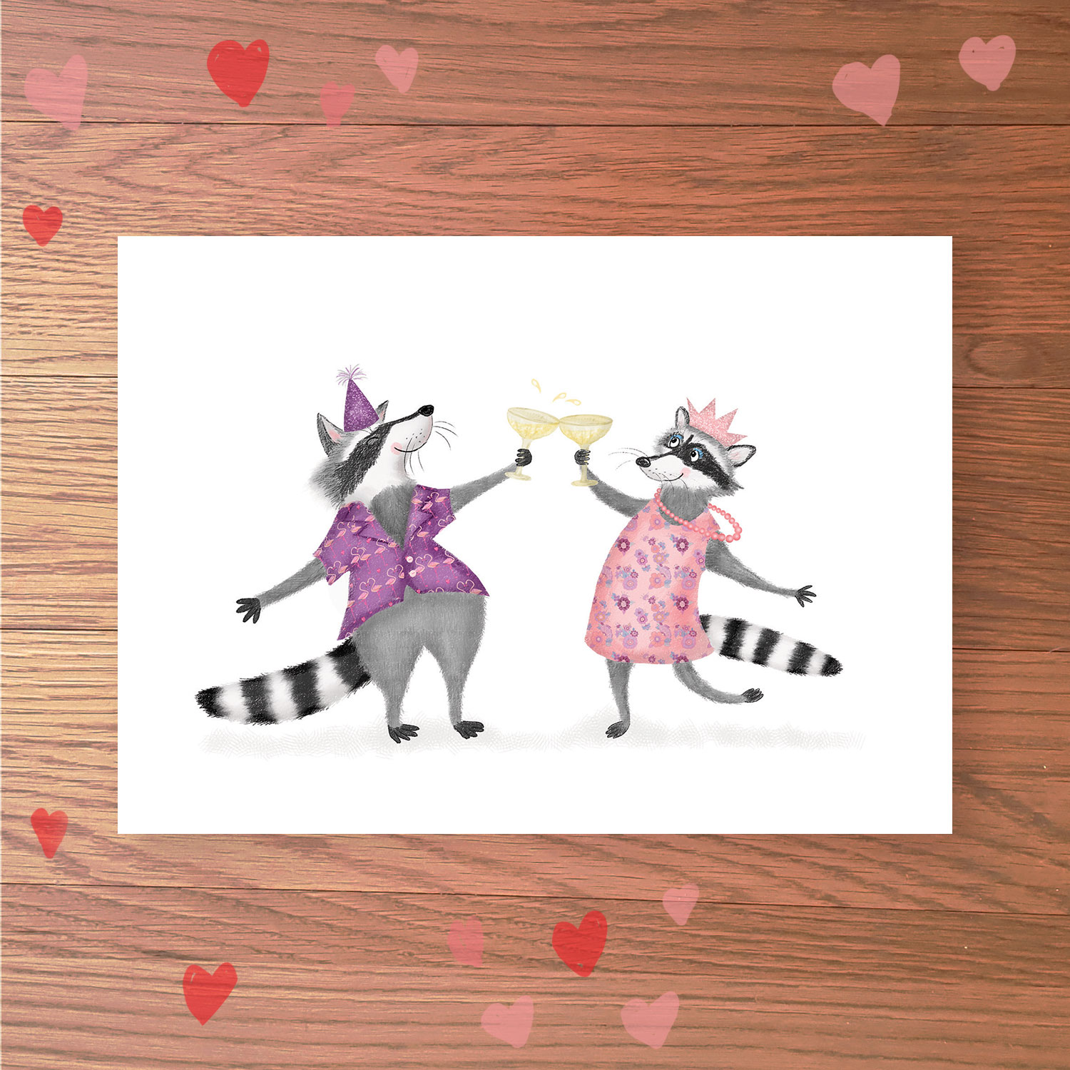 Greetings card with two raccoons in party clothes, clinking glasses of champagne together.