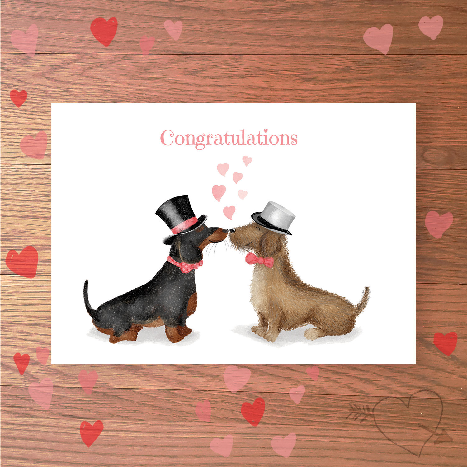 Greetings card with two dachshund dogs dressed as grooms, with Congratulations written above.