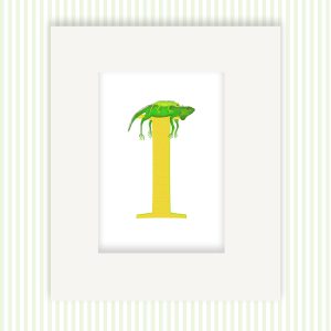 Mounted print hanging on the wall, of a yellow capital letter I with a cute mother iguana with her baby on her back.