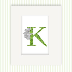 Mounted print hanging on the wall, of a green capital letter K with a cute mother koala with her baby on her back.
