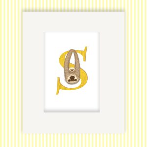 Mounted print hanging on the wall, of a yellow capital letter S with a cute mother and baby sloth.