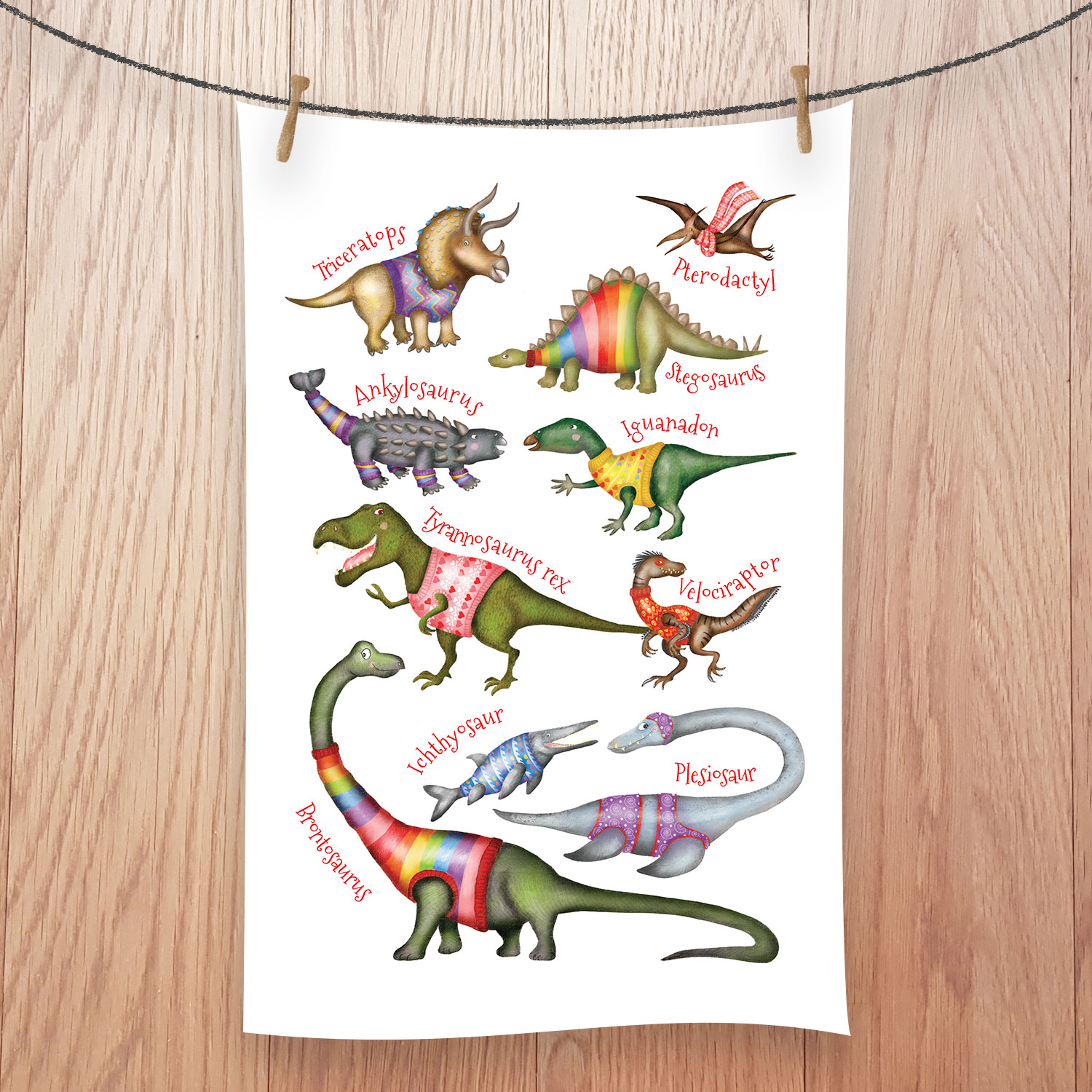 Tea towel featuring cute dinosaurs wearing colourful jumpers.
