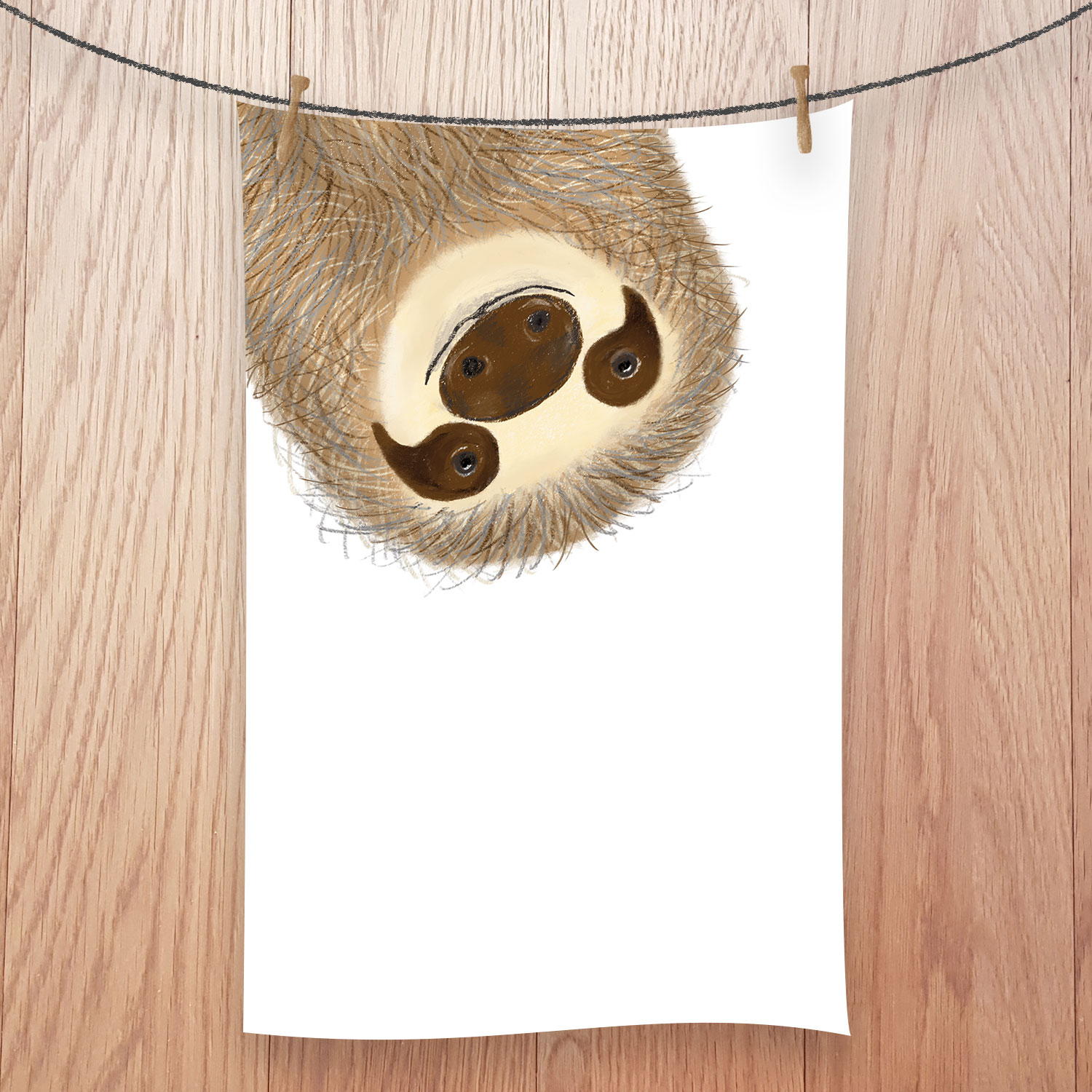 Tea towel with a sloth's face hanging downwards, smiling.
