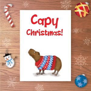 Christmas card with a capybara wearing a Christmas jumper and Capy Christmas! written above.