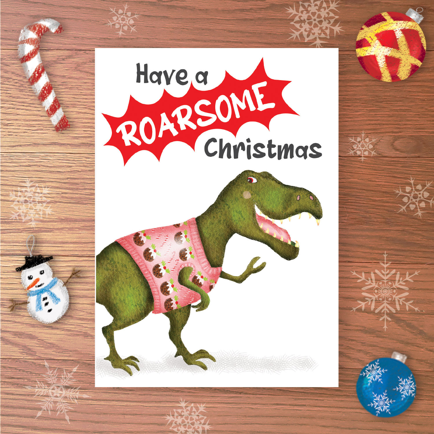 Greetings card with a T.rex dinosaur wearing a Christmas jumper, with Have a ROARSOME Christmas written above.