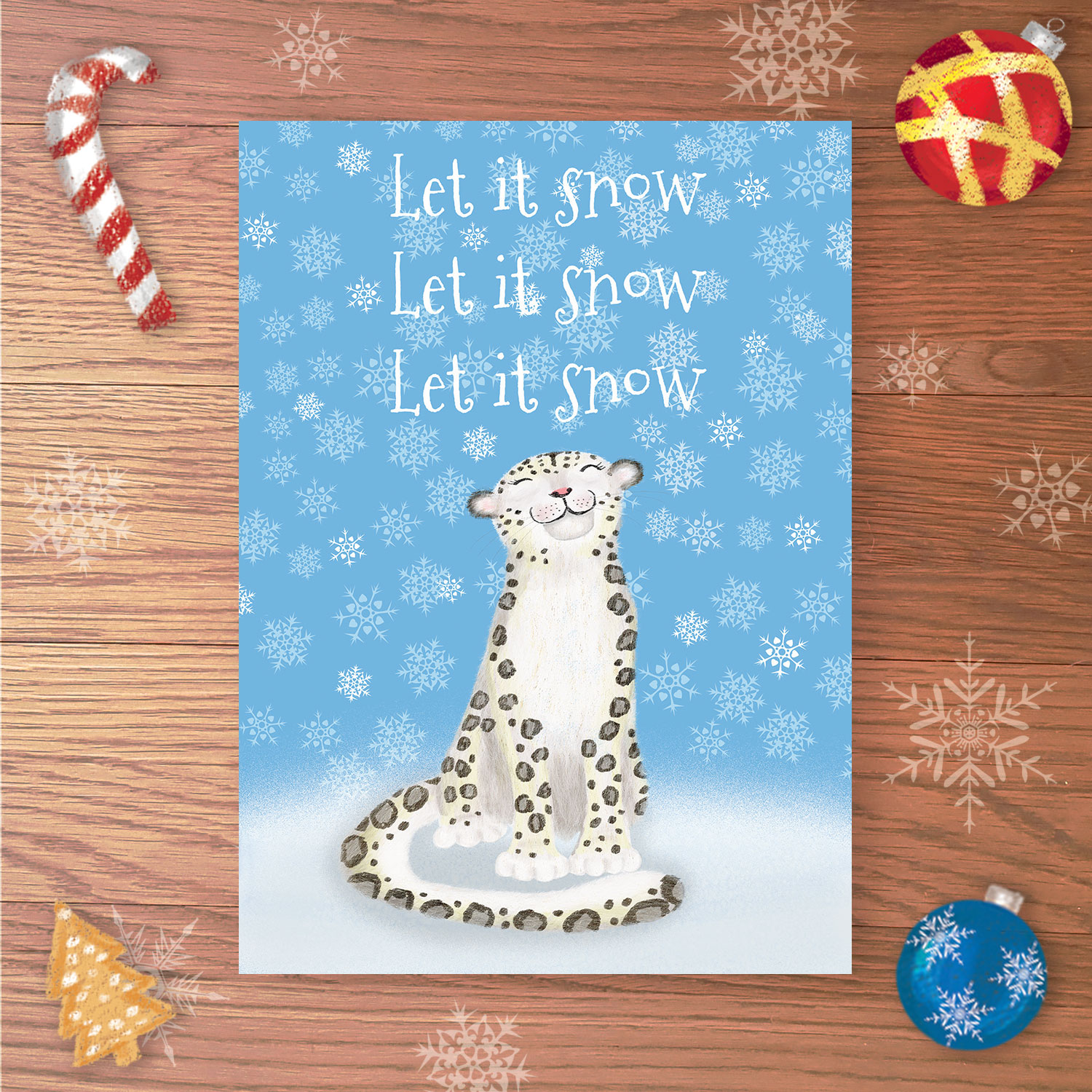 Christmas card with a snow leopard in a snowy scene and Let it snow, Let it snow, Let it snow written above.