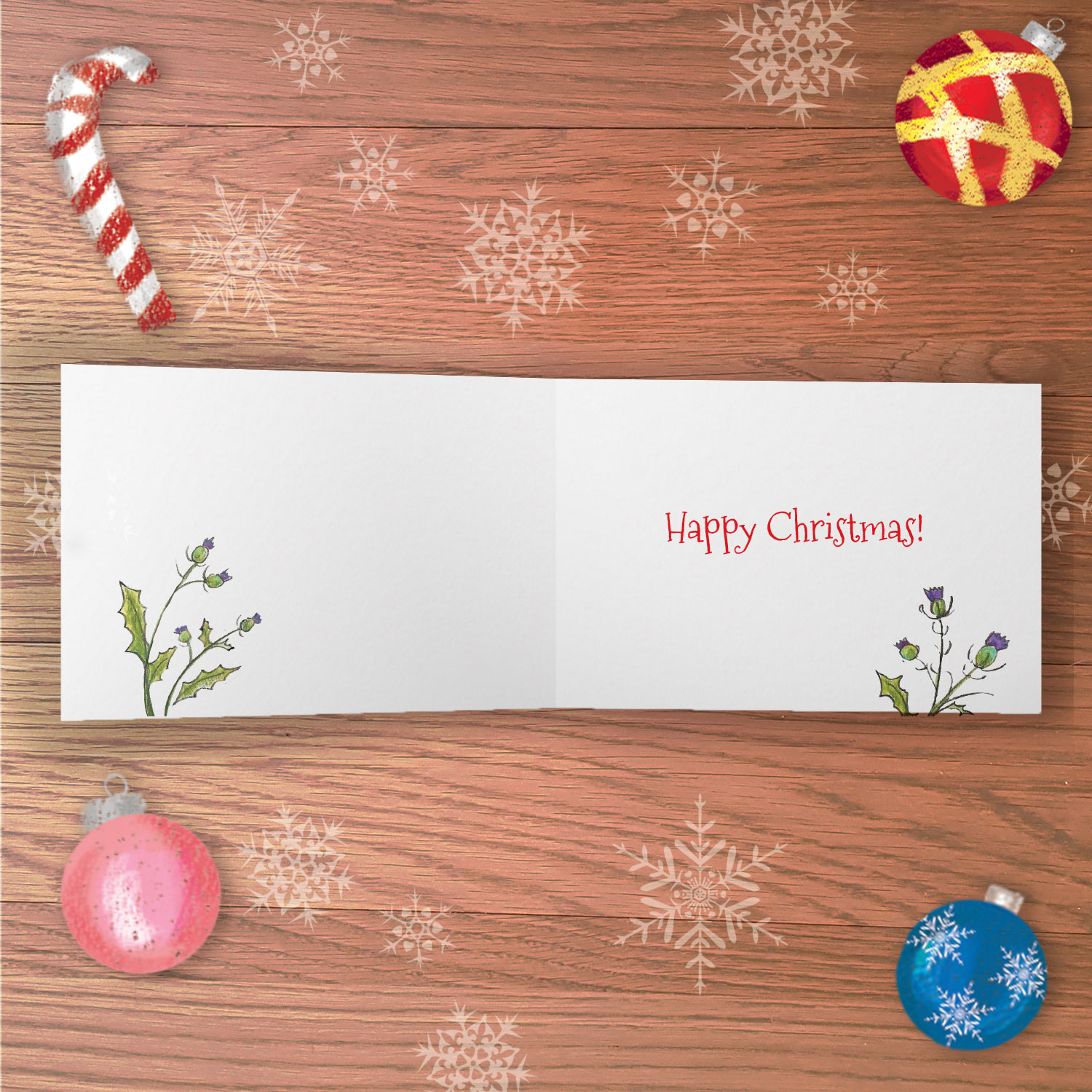 Open greetings card with Happy Christmas written inside and drawings of thistles.