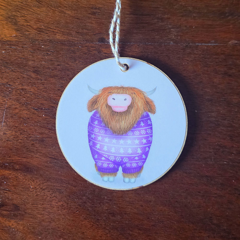 Hanging decoration featuring a Highland cow wearing a purple jumper,
