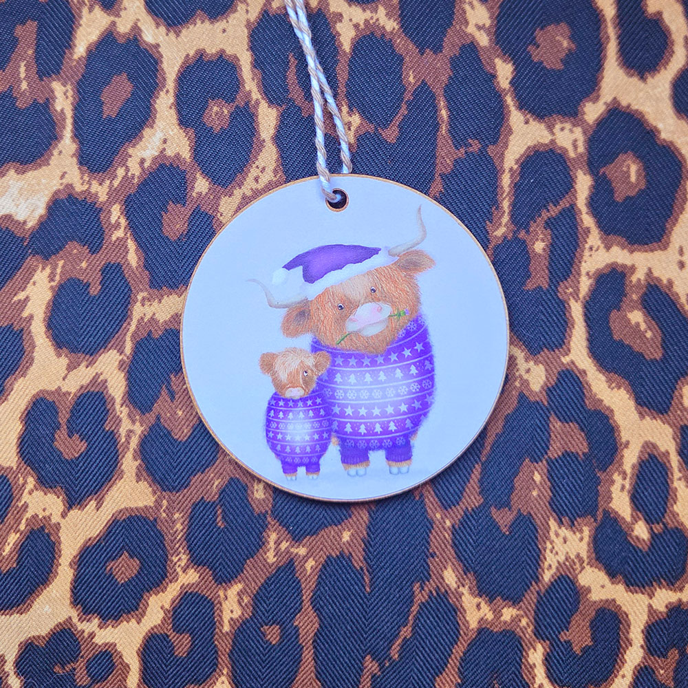 Hanging decoration featuring a mother Highland cow wearing a purple jumper and matching Santa hat, and her cute calf.